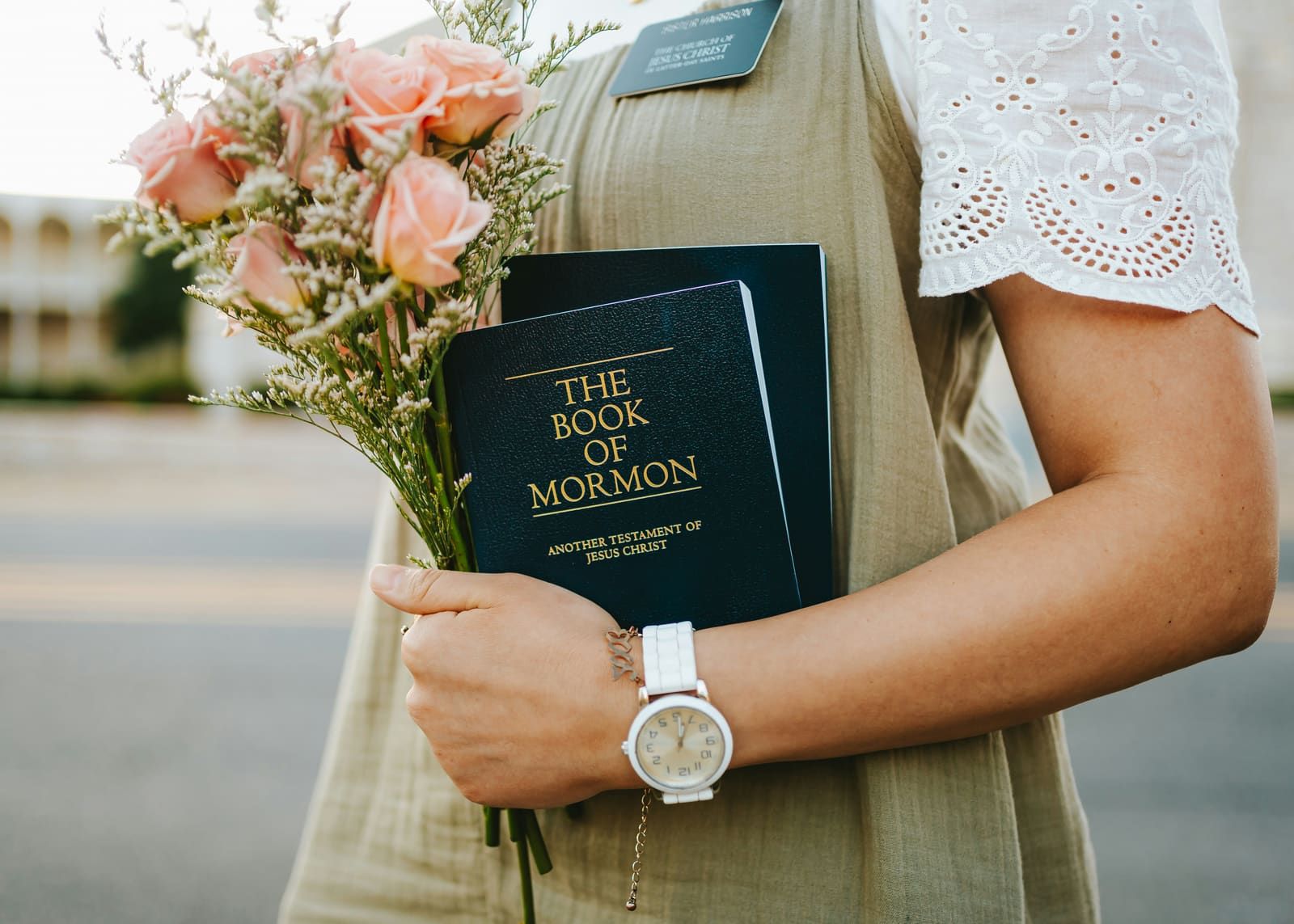 A missionary holding the Book of Mormon and flowers